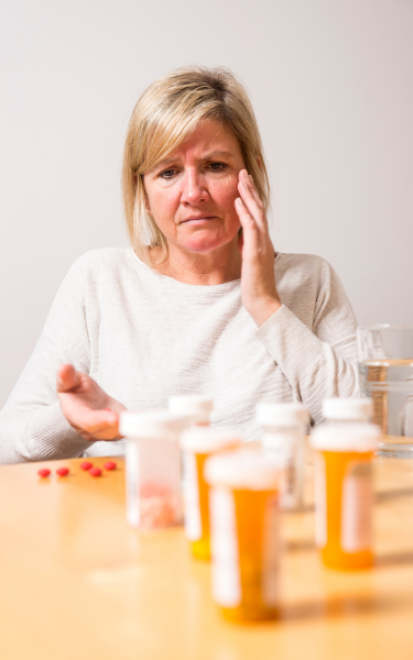Senior White Female Looking Sad About Multiple Prescription Medications